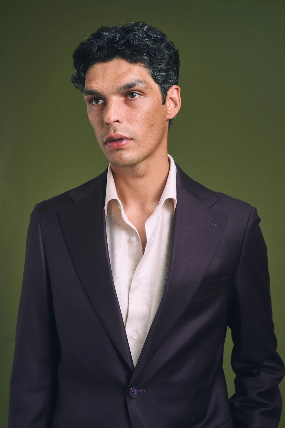 Close view of the Valsesia Loro Piana plum wool suit worn with an open shirt