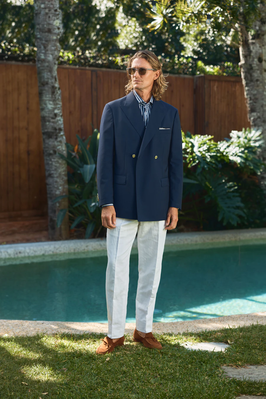 Full-length view of the Bowen navy wool jacket beside a pool
