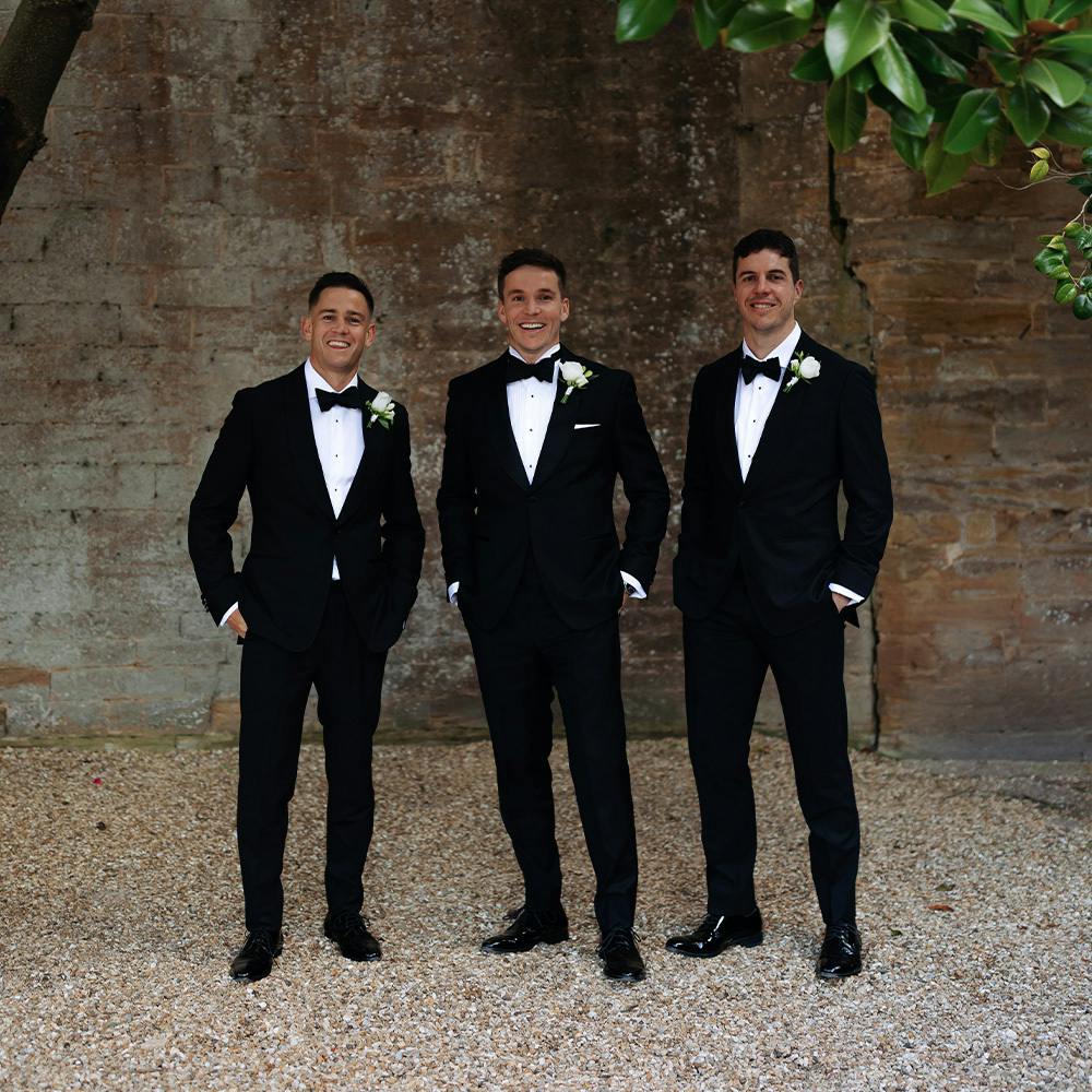 Groom and groomsmen wearing custom black tuxedos